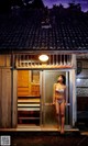 A woman in a white bikini standing in front of a door.
