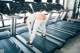 A woman is running on a treadmill in a gym.