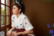 A woman in a kimono sitting by a window.