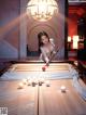 A woman is playing a game of pool. 