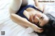 A woman laying on top of a white bed.