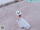 A woman in a white dress and a white hat.