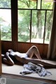 A woman laying on the floor in front of a window.